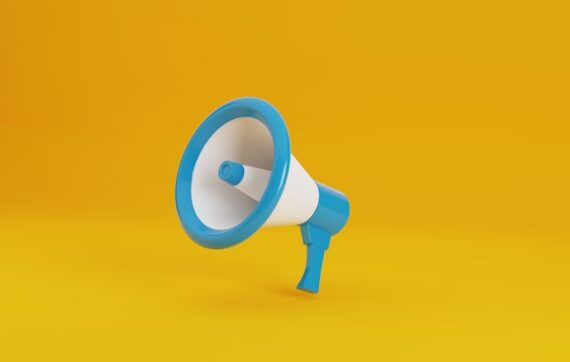 Un porte voix blanc et bleu turquoise sur un fond jaune vif pour illustrer cet article sur la définition du ton et de la voix dans une stratégie de communication
